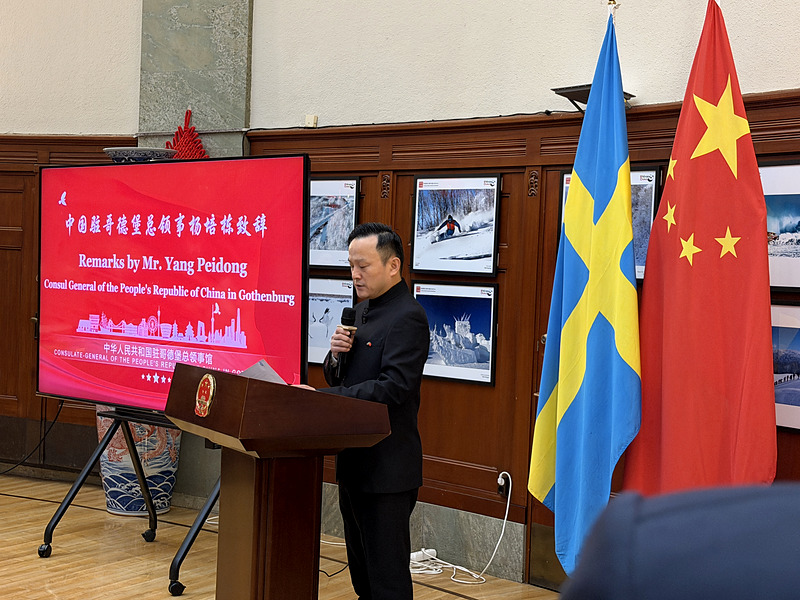 Consul General Yang Peidong delivering his remarks at the podium, beside the Swedish and Chinese flags