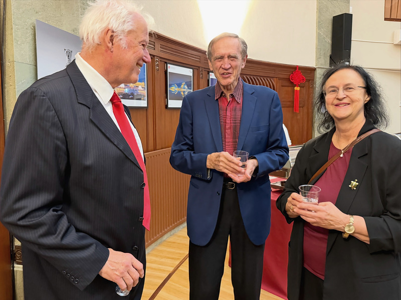 Three guests in conversation, holding glasses, in the reception hall