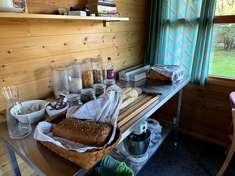 Bread, cereals and preserves laid out on a side table in the common room