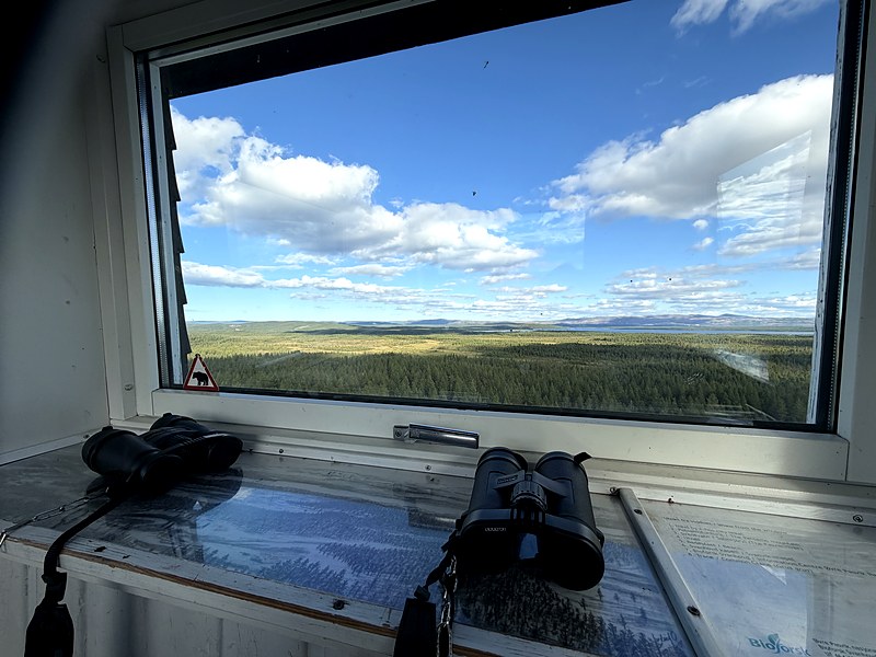 Binoculars and an old laminated map on the windowsill of the lookout tower